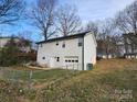 Back of house view showing walkout basement access, chain link fence and green trash can at 1545 Player Ct, Gastonia, NC 28054