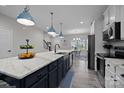 Modern kitchen with an island, white marble countertops, and stainless steel appliances at 201 Bennett Trail Dr, Mount Holly, NC 28120