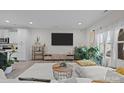 Spacious living room featuring large TV, white couch and natural light illuminating decor at 201 Bennett Trail Dr, Mount Holly, NC 28120