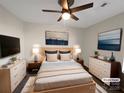 Staged primary bedroom features calming decor, with a large ceiling fan, dressers, and hardwood floors at 205 Mauney St, Mount Holly, NC 28120