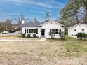 A charming white home with black shutters and a neatly landscaped yard creates a welcoming curb appeal at 2286 Kilborne Dr, Charlotte, NC 28205
