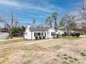 The side angle showcases the home's clean white facade, complemented by black shutters and a spacious yard at 2286 Kilborne Dr, Charlotte, NC 28205