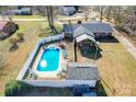 Aerial view of backyard featuring a pool, patio, shed, privacy fence, and screened in porch at 2659 Surrey Dr, Lincolnton, NC 28092