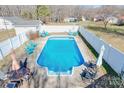Backyard in-ground pool is surrounded by a concrete deck, white fence, and an array of patio furniture at 2659 Surrey Dr, Lincolnton, NC 28092