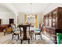 The formal dining room is filled with antique furniture, a decorative rug, and natural light from the window at 2988 Clover Nw Rd, Concord, NC 28027