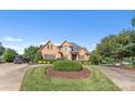 Beautiful brick home featuring a circular driveway, lush landscaping, and a well-manicured front lawn at 3759 Sand Wedge Dr, Gastonia, NC 28056
