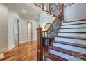 Elegant foyer featuring hardwood floors, a staircase with decorative iron spindles, and white trim at 4124 Sherbrooke Dr, Charlotte, NC 28210