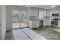 Modern kitchen with stainless steel appliances, granite countertops, and a sliding glass door leading to the deck at 5923 Rexwood Pl, Charlotte, NC 28210