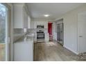 Bright kitchen featuring white cabinets, stainless steel appliances, granite countertops, and wood flooring at 5923 Rexwood Pl, Charlotte, NC 28210