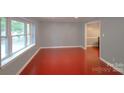 An empty living room featuring beautiful floors and light blue walls with large window at 6126 Eagle Peak Dr, Charlotte, NC 28214