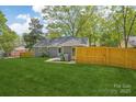 View of spacious backyard featuring a well-maintained lawn and a wood fence for privacy and space at 6813 Elm Forest Dr, Charlotte, NC 28212