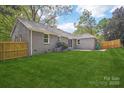 Expansive backyard featuring a well-maintained lawn with a wood fence ensuring privacy and space for outdoor activities at 6813 Elm Forest Dr, Charlotte, NC 28212