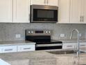 A close-up view of the kitchen featuring stainless steel appliances and granite countertops at 1102 Harry Ct, Albemarle, NC 28001