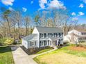 Beautiful two-story home with blue siding, black shutters and mulch, green grass, and a cozy front entrance at 1133 Bloom Wood Ln, Matthews, NC 28105