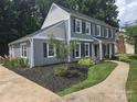 A charming home with gray siding, black shutters, manicured landscaping, and inviting curb appeal at 1133 Bloom Wood Ln, Matthews, NC 28105