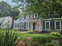 Attractive home with gray siding, black shutters, a green lawn, and an American flag displayed at 1133 Bloom Wood Ln, Matthews, NC 28105