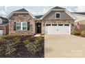 Charming stone and siding exterior featuring a two-car garage and landscaped front yard at 12609 Twilight Dr, Mint Hill, NC 28227