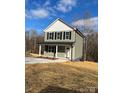 Inviting two-story home with green siding, black shutters, and covered front porch at 1425 Wildwood Dr, Kannapolis, NC 28081