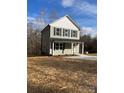 Two-story home featuring green siding, black shutters, and a welcoming covered front porch at 1425 Wildwood Dr, Kannapolis, NC 28081