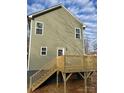 Home's rear exterior featuring green siding and a wooden deck with stairs to the backyard at 1425 Wildwood Dr, Kannapolis, NC 28081