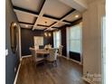 Bright dining room features an elegant chandelier, wood floors, coffered ceilings, and lots of natural light at 228 Heatherland Dr, Rock Hill, SC 29732