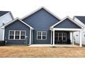 Backyard view featuring siding, a covered patio with furniture, and a well-maintained lawn area at 2617 Manor Stone Way, Indian Trail, NC 28079