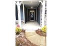 Inviting entryway with a covered porch, stone accents, and a decorative front door at 2617 Manor Stone Way, Indian Trail, NC 28079