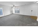 Spacious living room with neutral carpet, large windows, ceiling fan, and an inviting open floor plan at 2643 Meadow Knoll Dr, Charlotte, NC 28269