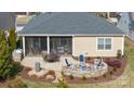 Inviting backyard with a fire pit, a patio dining area, and a screened-in porch at 305 Hemlock Bluff Ct, Denver, NC 28037
