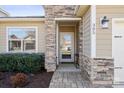 Inviting front entrance with stone accents, paved walkway, and well-maintained landscaping at 305 Hemlock Bluff Ct, Denver, NC 28037