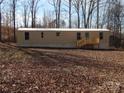 This mobile home features an inviting wooden deck and plenty of natural light and is surrounded by trees at 335 Lake Landing Dr, Salisbury, NC 28146