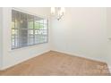 Well-lit dining room with neutral carpet and a large window offering serene outdoor views at 5011 Sharon Rd # J, Charlotte, NC 28210