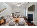 Bright living room with fireplace, hardwood floors, stylish furniture, and a ceiling fan at 5084 Parkview Way, Matthews, NC 28104