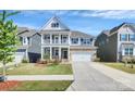Charming two-story home featuring a well-manicured lawn, covered porch and two-car garage at 805 Deep River Way, Waxhaw, NC 28173