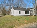 White house with green lawn surrounded by trees in a peaceful neighborhood at 811 Austin St, Albemarle, NC 28001