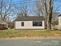 Side view of a charming house with a black roof and large window at 811 Austin St, Albemarle, NC 28001