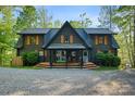 Charming log home with a covered front porch, wooden shutters, and inviting entrance at 106 Mcnaron Ln, Mooresville, NC 28117