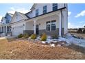 Exterior view of a two-story home with a covered front porch and nicely landscaped front yard at 107 Megby Trl, Statesville, NC 28677