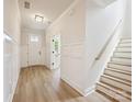 Bright foyer featuring hardwood floors, paneled walls, and a staircase at 13126 Macon Hall Dr, Mint Hill, NC 28227