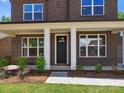 Charming brick home entrance with manicured landscaping and white-trimmed windows at 13126 Macon Hall Dr, Mint Hill, NC 28227