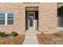 Inviting front door of a home with a stone exterior, glass door, and a welcoming entrance at 1645 Unison Dr, Charlotte, NC 28262