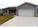 Attractive home with gray vinyl siding, one-car garage, and concrete driveway, blending charm and functionality at 203 S Hill Ave # 3, Albemarle, NC 28001