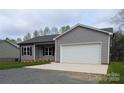 Single-Gathering home with gray siding, black shutters, and a two-car garage showcasing a well-maintained exterior at 203 S Hill Ave # 3, Albemarle, NC 28001
