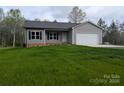 Attractive single-story home featuring gray siding, black shutters, a pristine lawn, and an attached two-car garage at 203 S Hill Ave # 3, Albemarle, NC 28001
