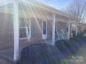 Inviting covered front porch with brick facade, rocking chairs and meticulously maintained landscaping at 2883 Westfield Nw Ave, Concord, NC 28027