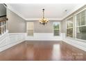 Spacious dining room with hardwood floors, wainscoting, and large windows providing ample natural light at 3004 Fallondale Rd, Waxhaw, NC 28173