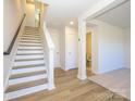 Bright entryway with hardwood floors, staircase, and a view into the downstairs bathroom at 3904 Craig Ave, Charlotte, NC 28211
