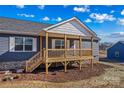 Lovely covered front porch with wood railings and stairs on a home with blue siding at 451 Lookout Dam Rd, Statesville, NC 28625
