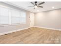 Bright living room with new flooring, crown molding, a ceiling fan, and a large window at 608 E Matthews St, Matthews, NC 28105