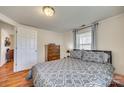 Comfortable main bedroom featuring wood-look flooring, a dresser, a plush bed with patterned bedding, and natural light at 102 Fire Department Dr, Belmont, NC 28012